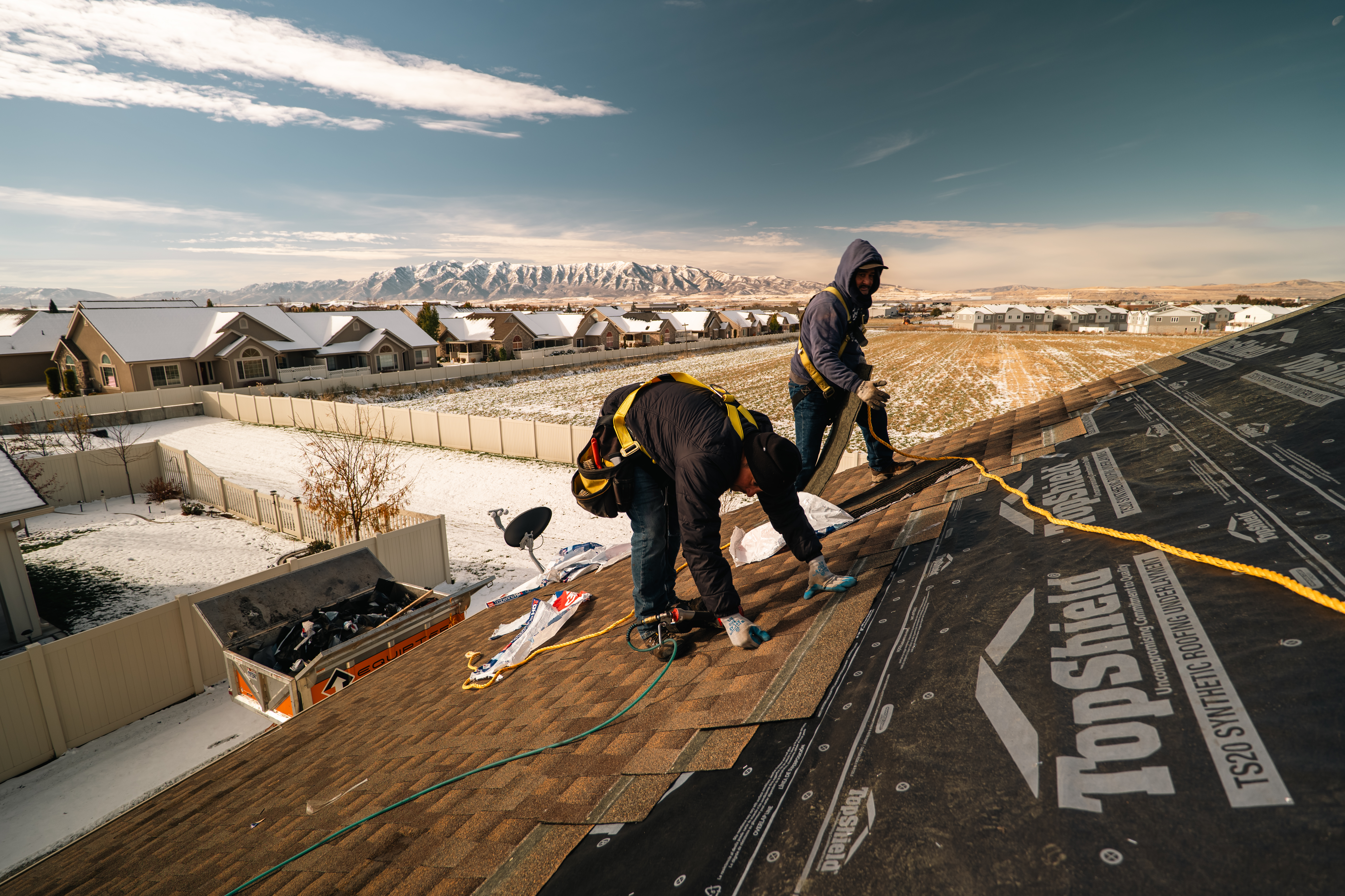 Homer Roofing crew tearing off old shingles during a roof replacement in Utah