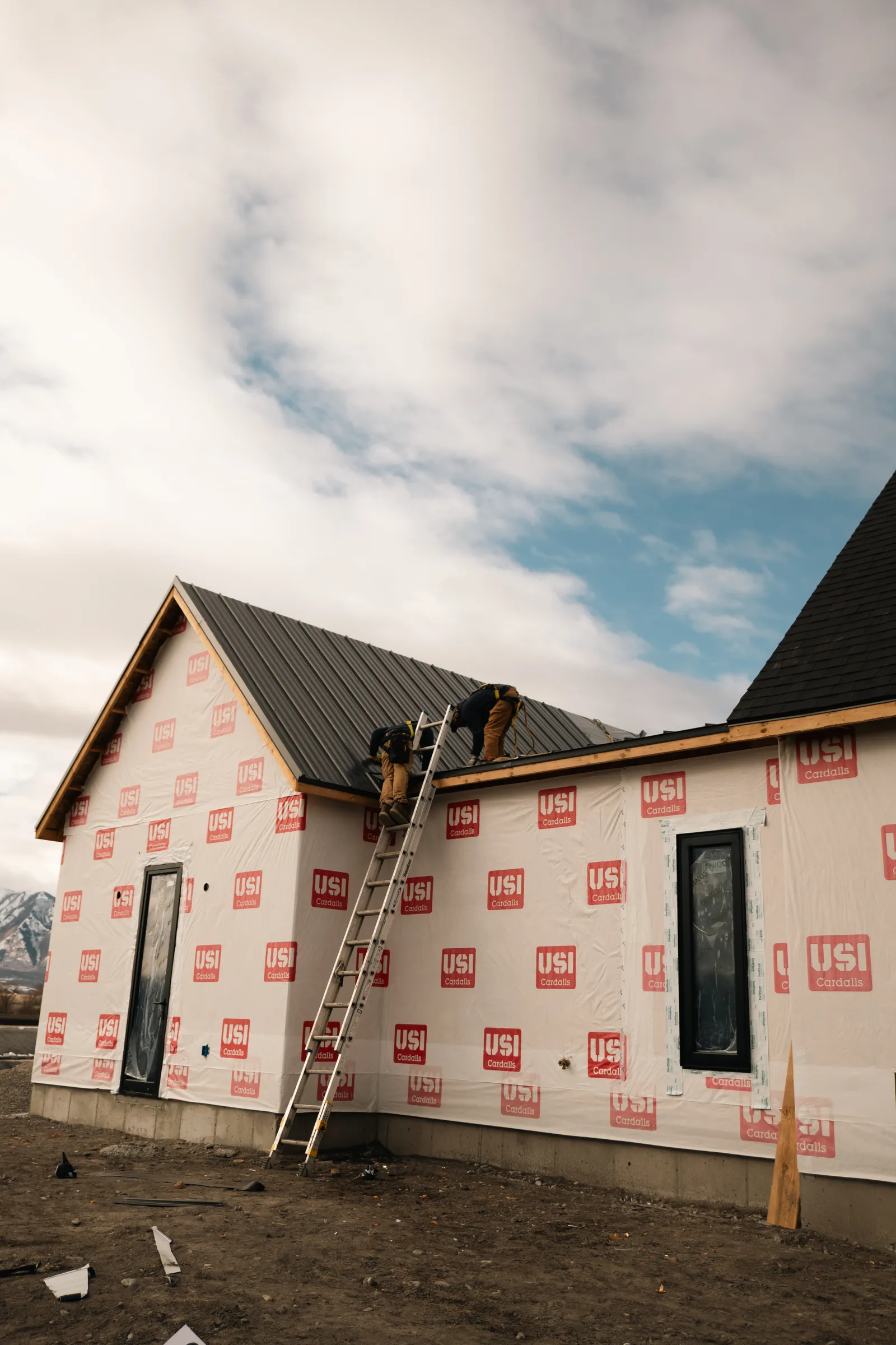 Homer Roofing crew installing a standing seam metal roof on a new construction home in Northern Utah