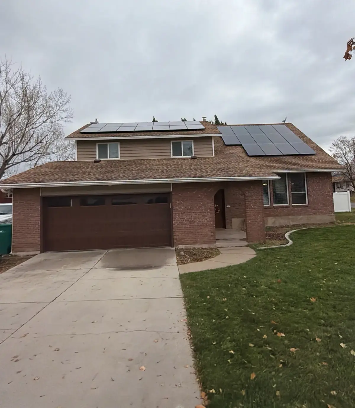 Front exterior of a two-story Roy, Utah home after asphalt shingle roof replacement by Homer Roofing