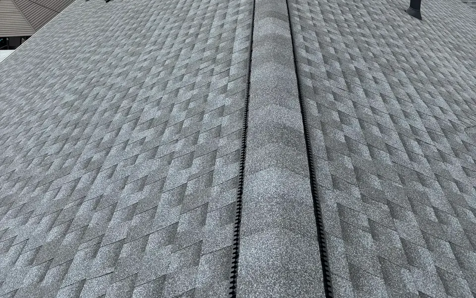 Ridge vent running along the peak of a new shingle roof
